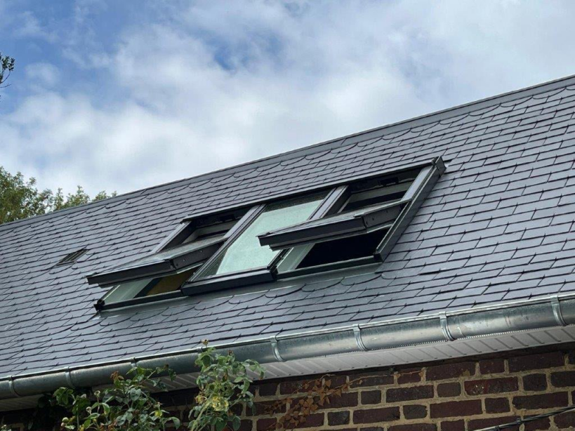 vue extérieure d'une maison avec toiture ardoise avec une verrière 3 en 1 VELUX. 2 VELUX sont ouverts et un fermé