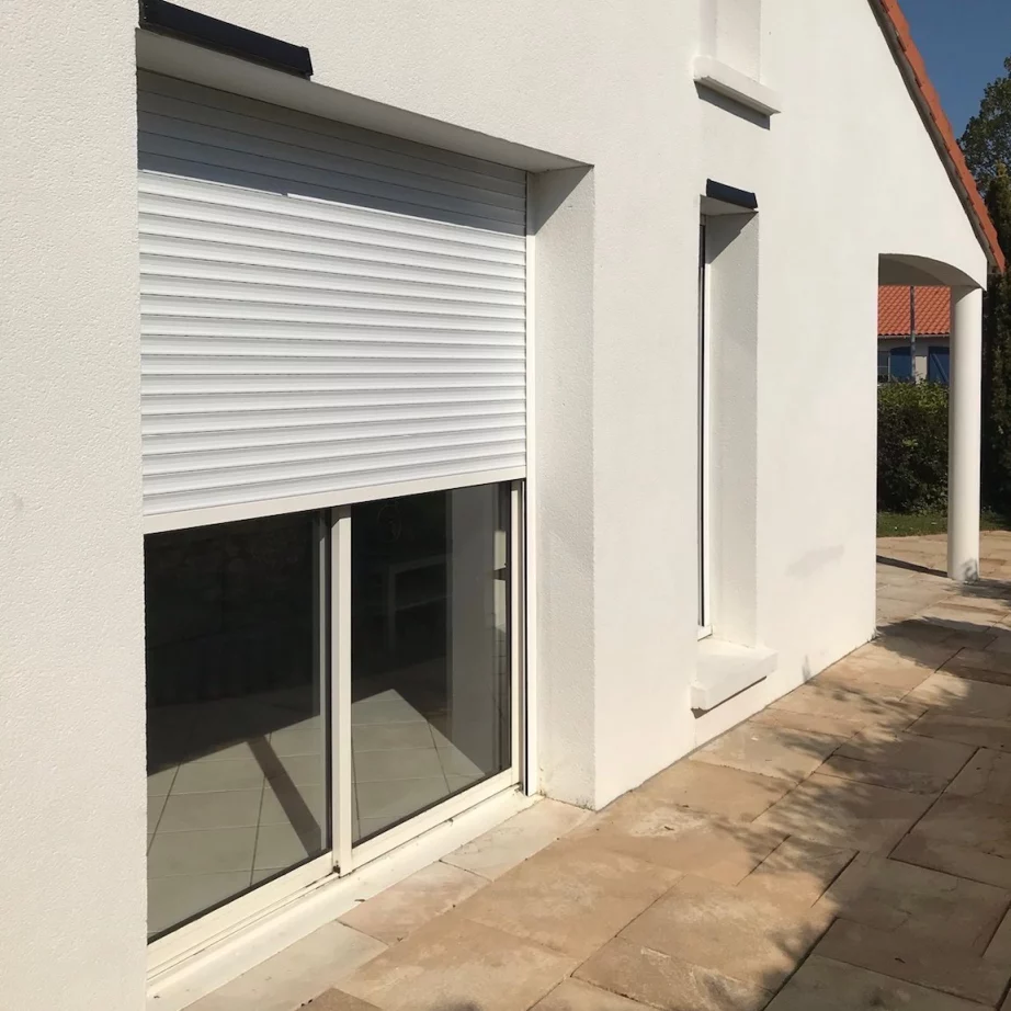 Artim Menuisier Cholet Volet IMG 0009 Façade de maison avec une baie coulissante avec un volet roulant à moitié fermé
