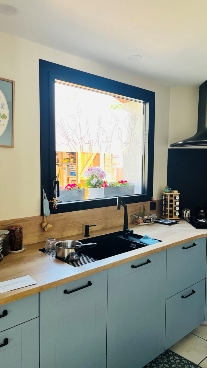 cuisine moderne de style industriel avec plan de travail en bois et fenêtre, hotte noires