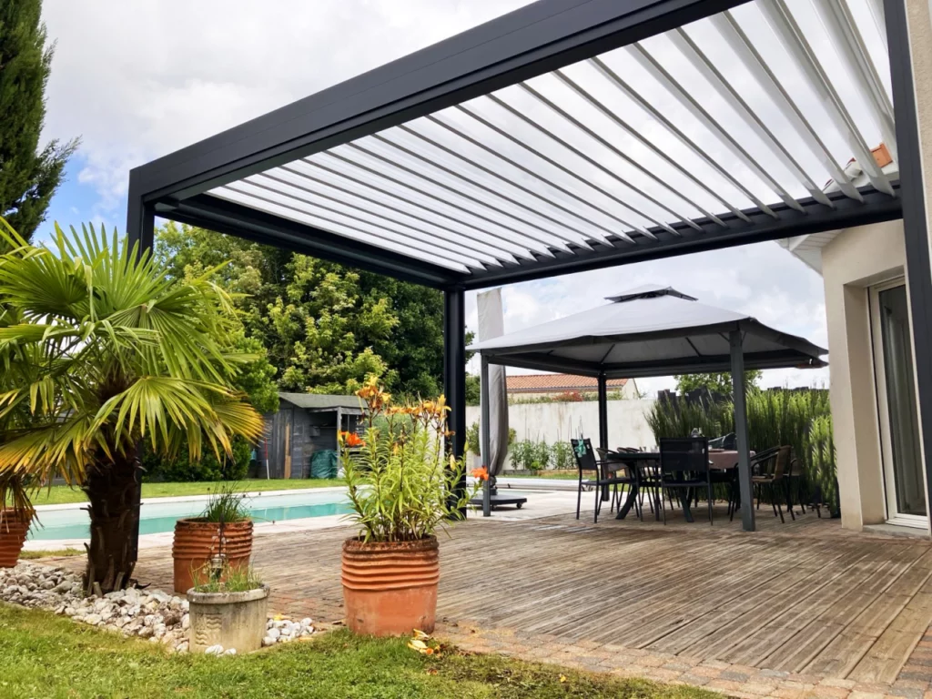 pergola bioclimatique sur une terrasse bois arborée avec vue sur la piscine