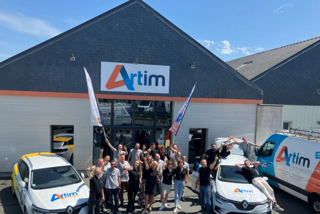 équipe de collaborateur d'ARTIM devant l'entreprise à Cholet les bras levés