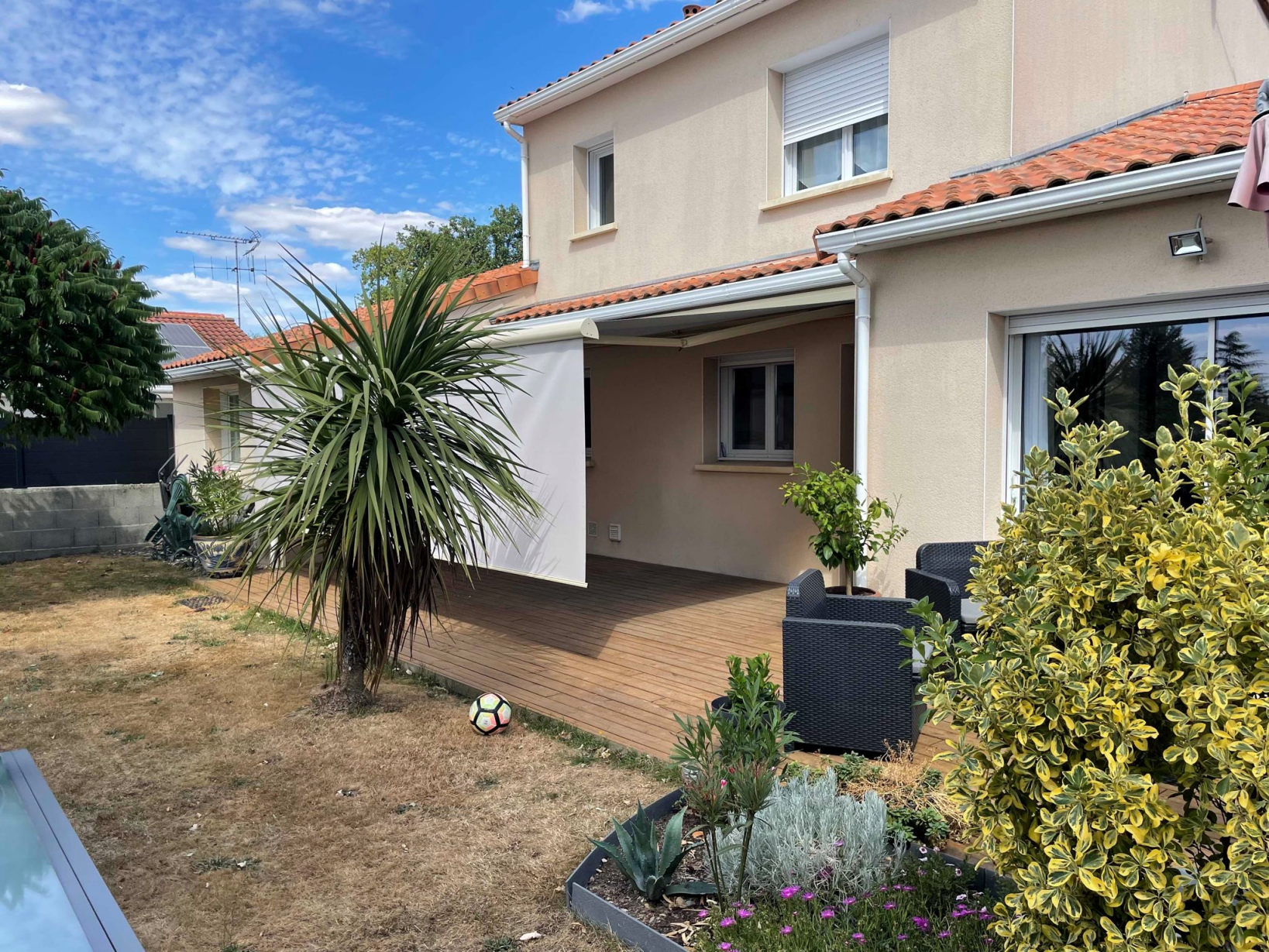 Artim Menuisier Cholet Store Banne IMG 2031 store banne beige sur la terrasse bois d'une maison à Cholet