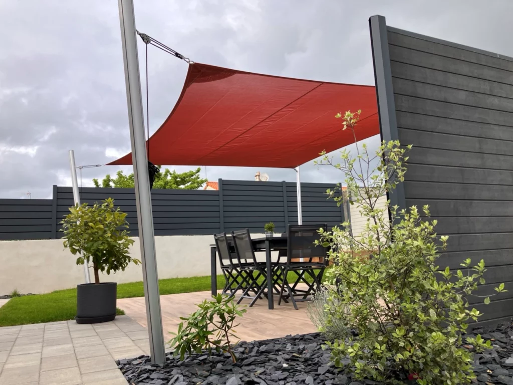 voile d'ombrage terra cotta entre 4 poteaux sur la terrasse d'une maison à Beaupréau