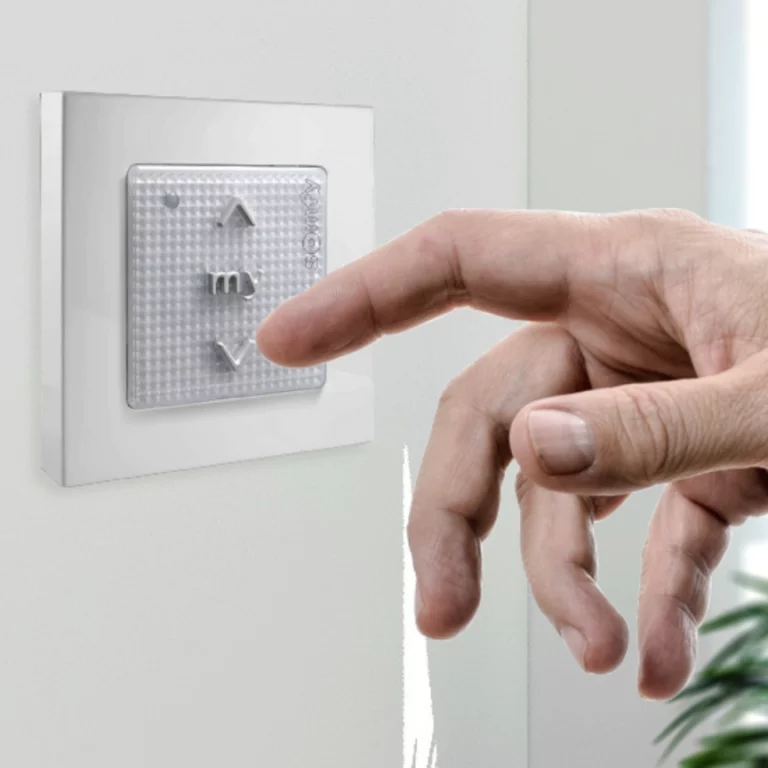 télécommande de volet roulant somfy smoove avec doigt qui appuie dessus