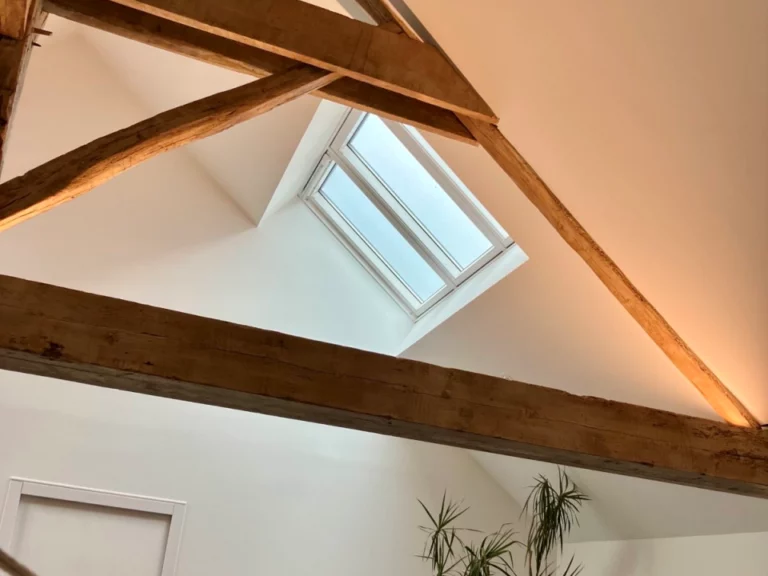 verrière 3 en 1 VELUX dans un séjour avec hauteur sous plafond poutres à Cholet