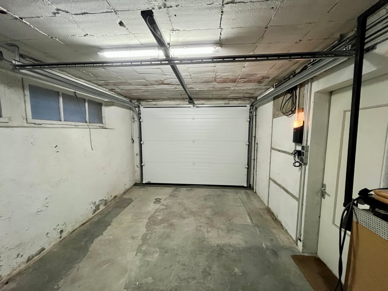 Artim Menuisier Cholet Porte Garage Cholet IMG 8810 vue de l'intérieur d'un garage à Cholet, Porte de garage sectionnelle plafond blanche dans un garage vide