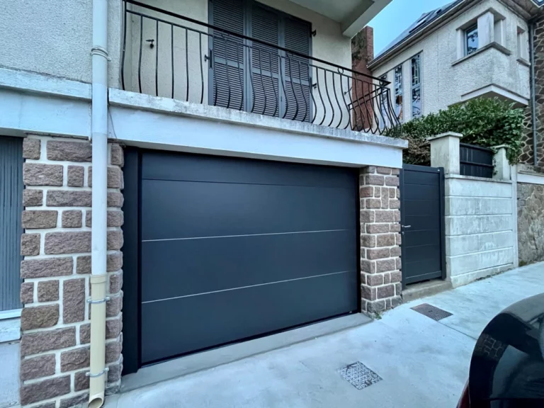 face d'une maison de ville avec fenêtres et mur en brique et porte de garage gris
