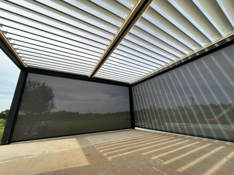 Pergola bioclimatique avec stores latéraux fermés pour protéger une terrasse du vent et du soleil