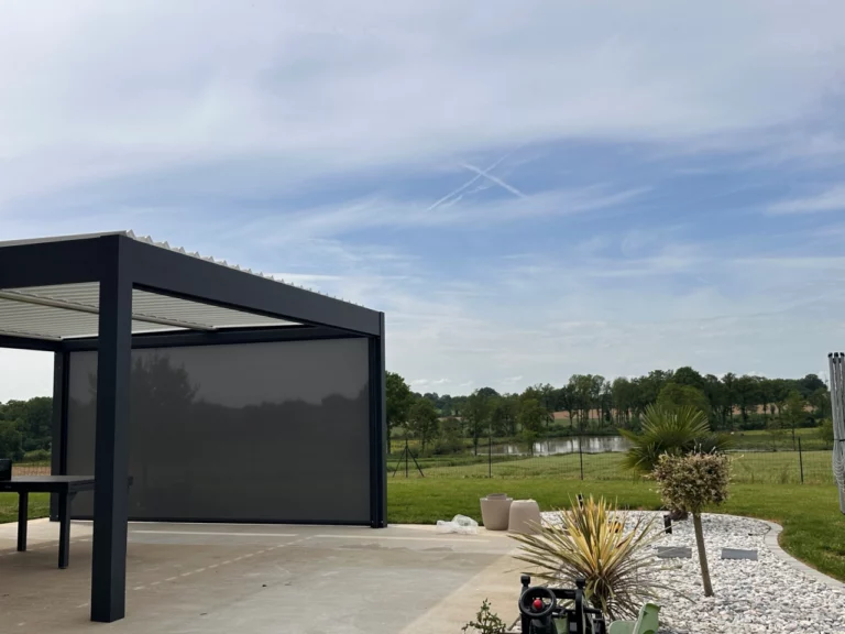 Pergola bioclimatique anthracite avec store vertical sur une terrasse ouverte sur le jardin