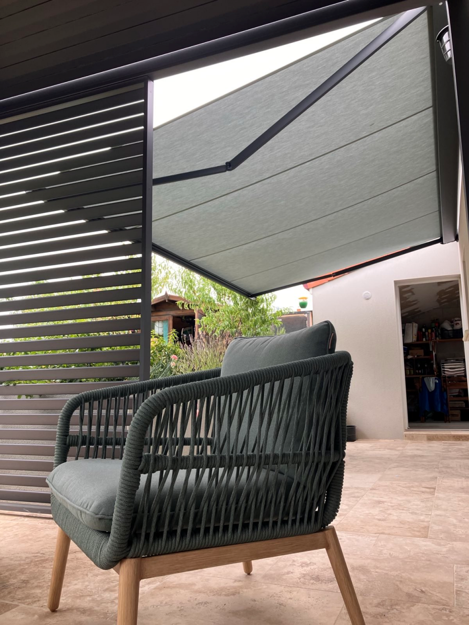 Artim Menuisier Cholet Store BanneIMG 1513 Store banne posé près d’un brise-vue, coin détente ombragé et confortable sur terrasse carrelée.