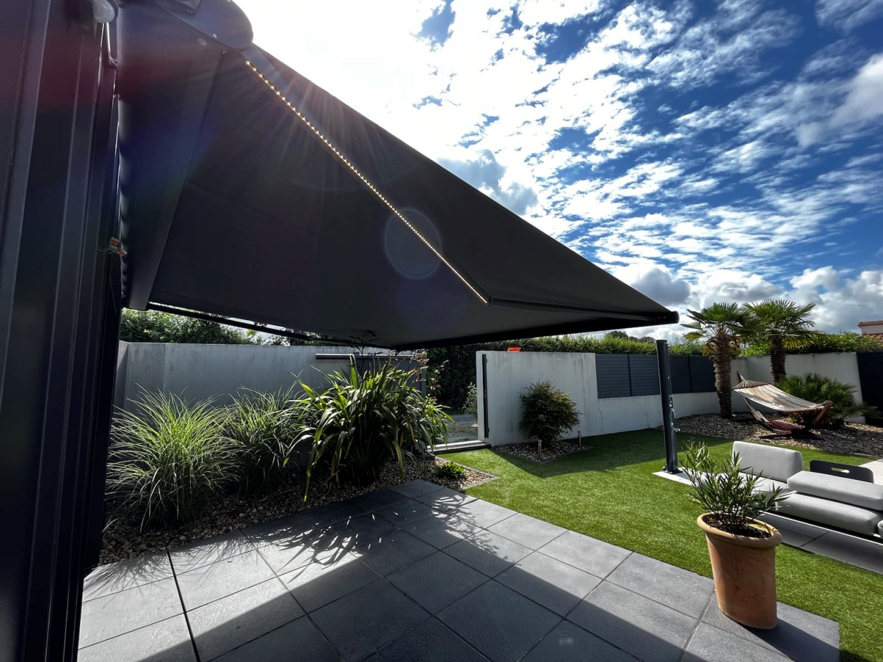 Artim Menuisier Cholet Store BanneIMG 1857 Store banne toile claire au bord d’une piscine, protection solaire pour transats et terrasse.