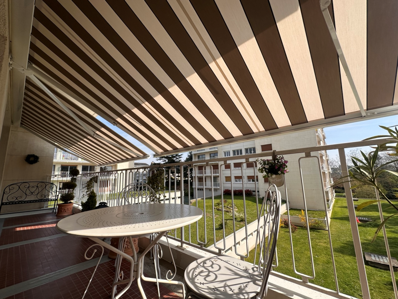 Artim Menuisier Cholet Store BanneIMG 4821 Store banne toile beige sur maison blanche, installation sobre pour ombrager la terrasse.