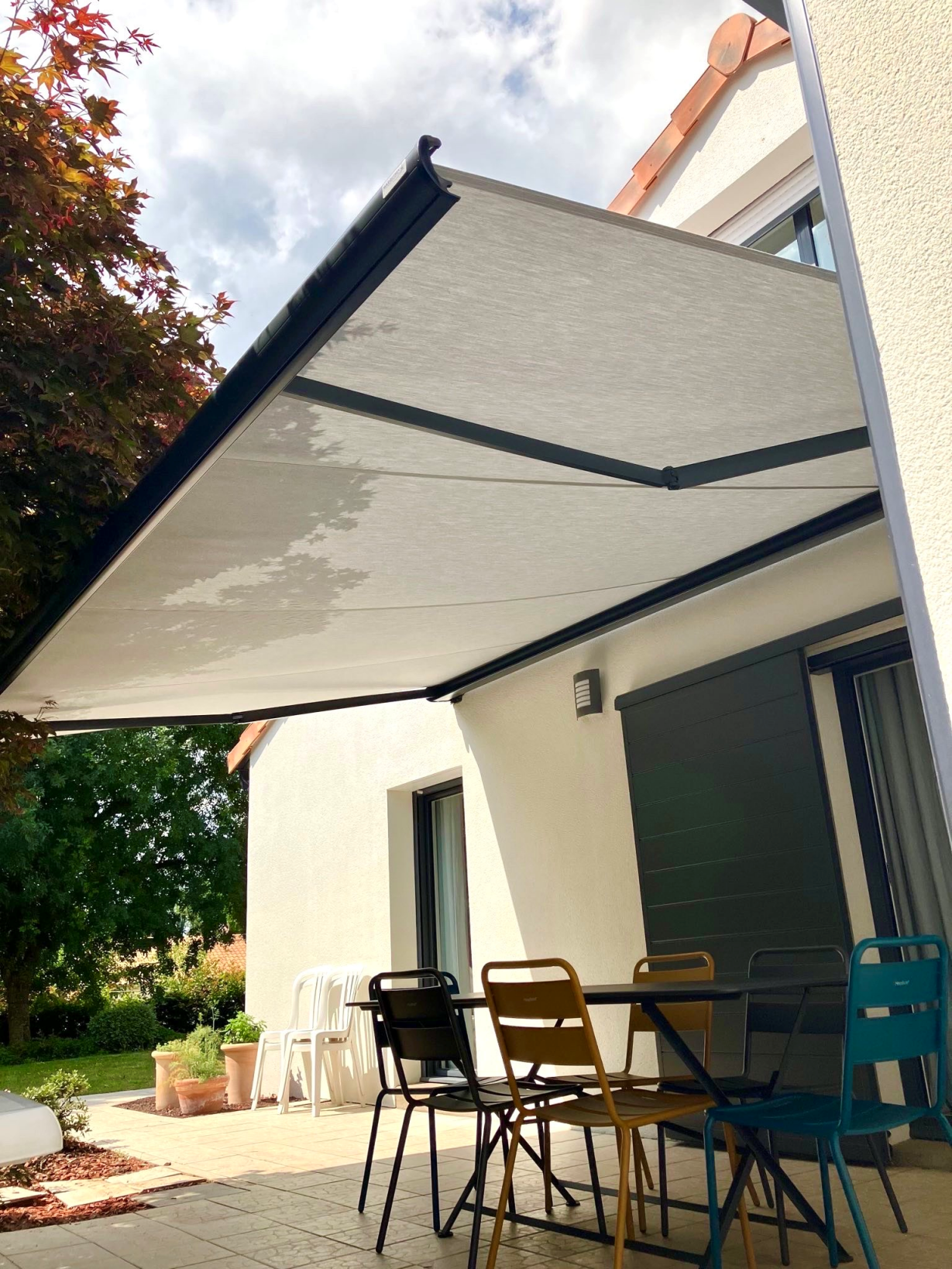 Artim Menuisier Cholet Store Bannesignal 2024 04 26 151936 002 Store banne anthracite déployé sur jardin, ombre large et ambiance haut de gamme.