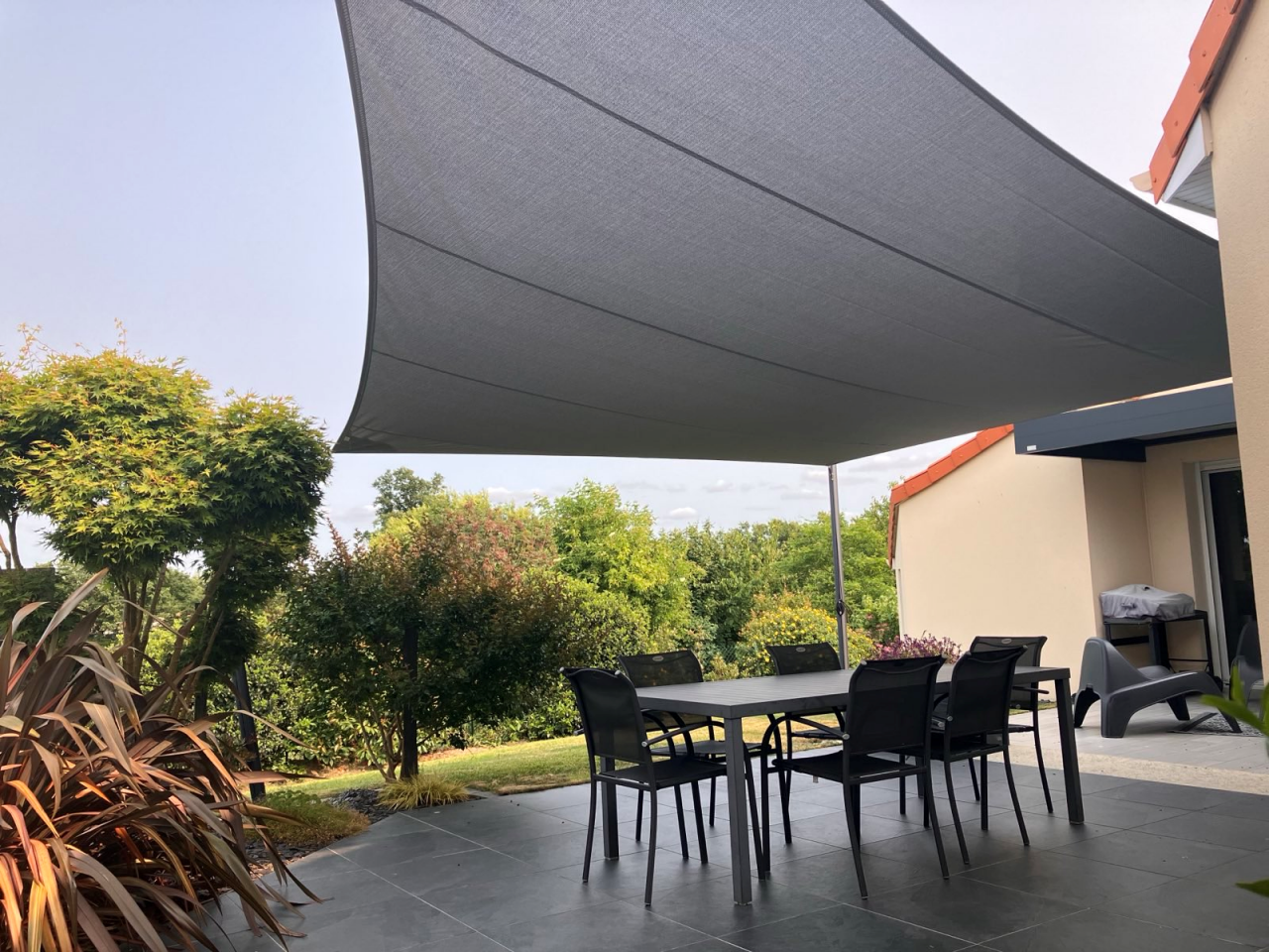 Artim Menuisier Cholet Voile Ombrage CholetIMG 1311 Voile d’ombrage grise sur mesure au-dessus d’une table de terrasse, protection solaire élégante – ARTIM nantes