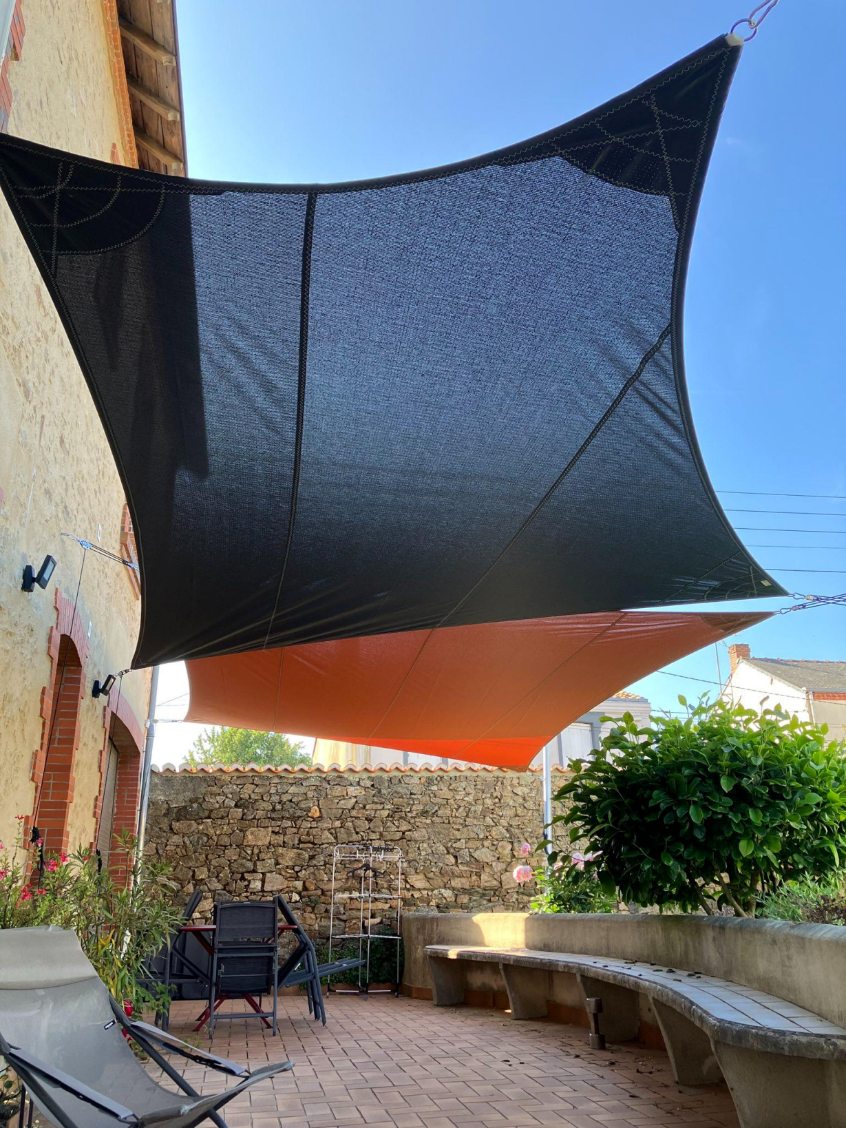 Artim Menuisier Cholet Voile Ombrage Choletsignal 2023 05 31 102531 002 Voile d’ombrage sur mesure noir et terracotta tendue dans une cour, création d’ombre sur terrasse – ARTIM cholet