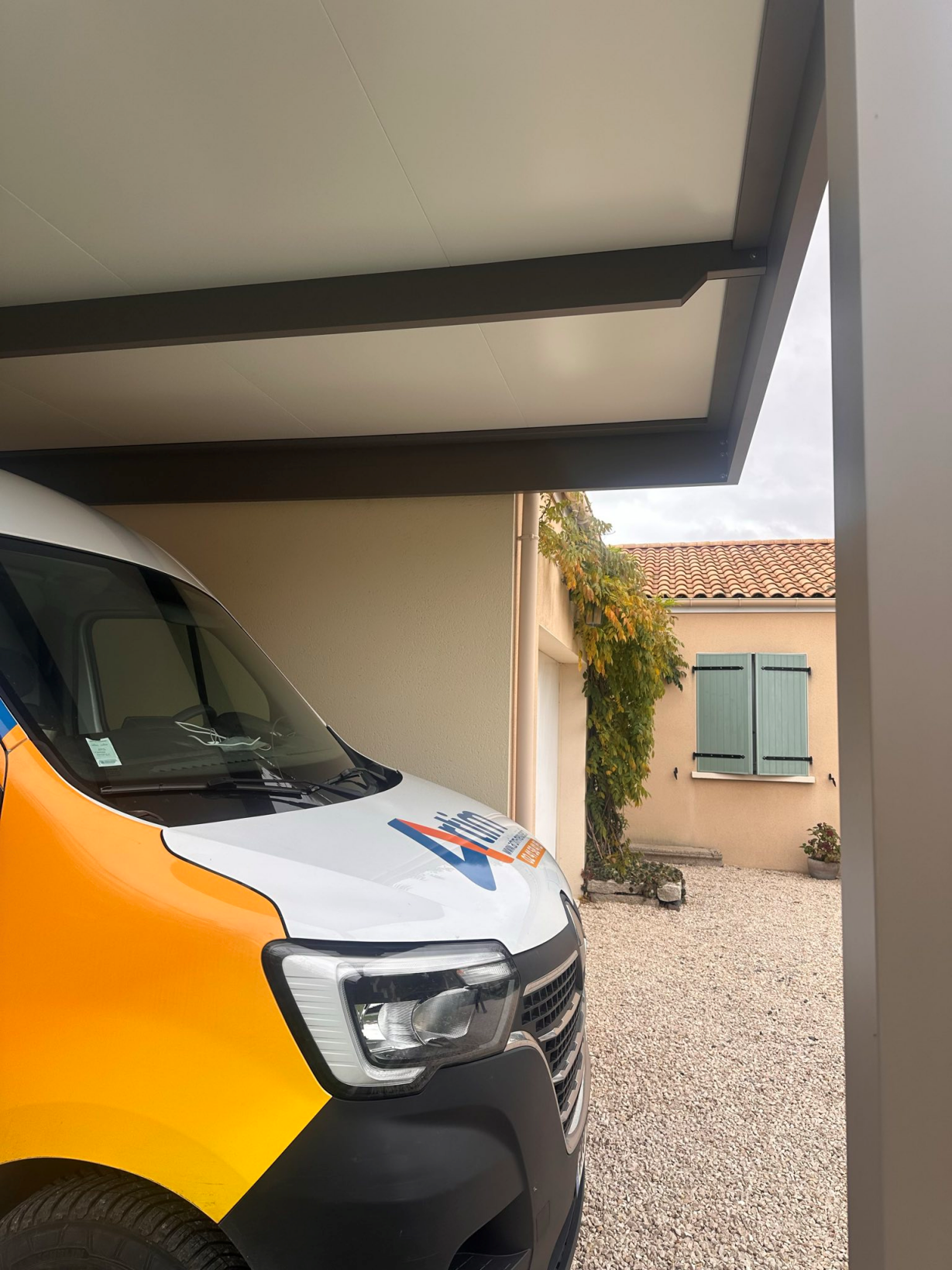 Artim Menuisier Cholet Carport Cholet IMG 1677 Détail de la sous-face d’un carport aluminium avec véhicule utilitaire stationné dessous
