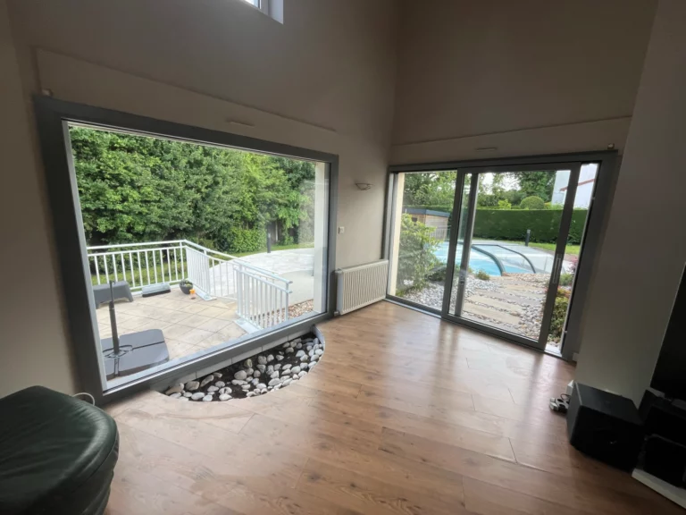 Grande baie vitrée isolante avec vue sur terrasse et jardin à Cholet