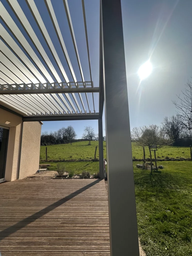 Pergola bioclimatique sur terrasse bois avec lames orientables ouvertes
