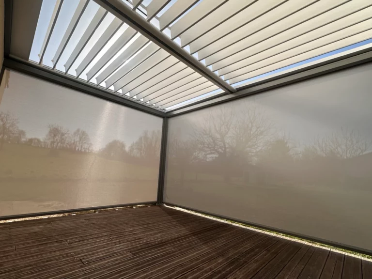 Pergola bioclimatique avec stores screen fermés sur une terrasse bois près de Bressuire